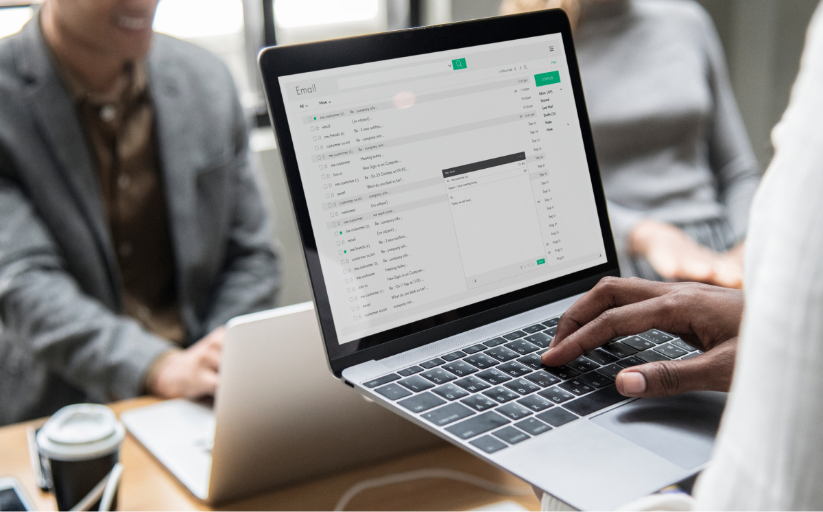 A person sitting at a desk using a laptop displaying a bright screen.